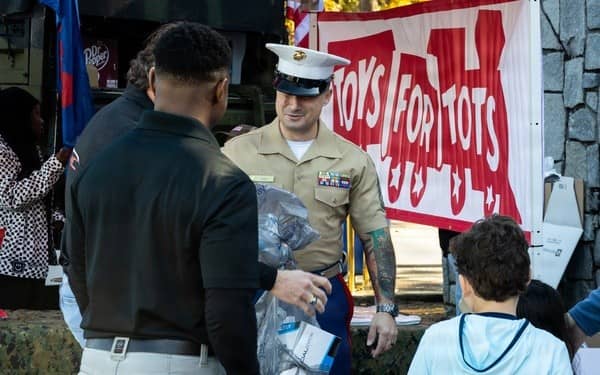 Marine with families at Toys for Tots toy drive