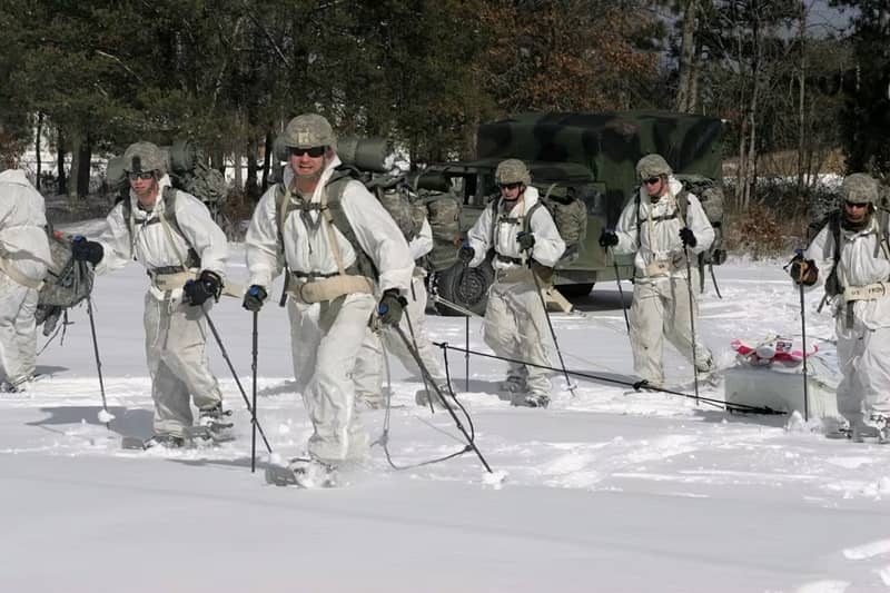 Soldiers hiking over snow on skis