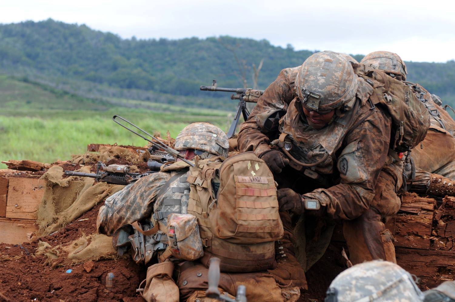 Soldiers utilizing tactical backpack in field