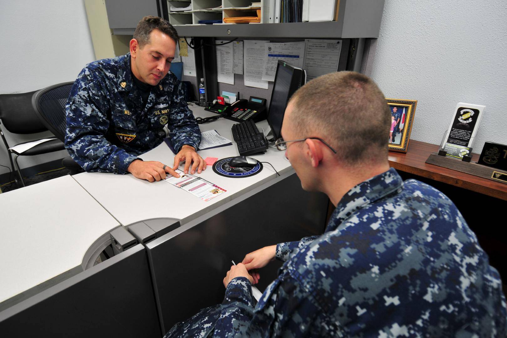 Two Navy Sailors Discussing Paperwork