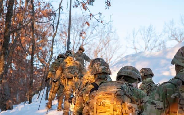 Group of soldiers hiking uphill in the snow