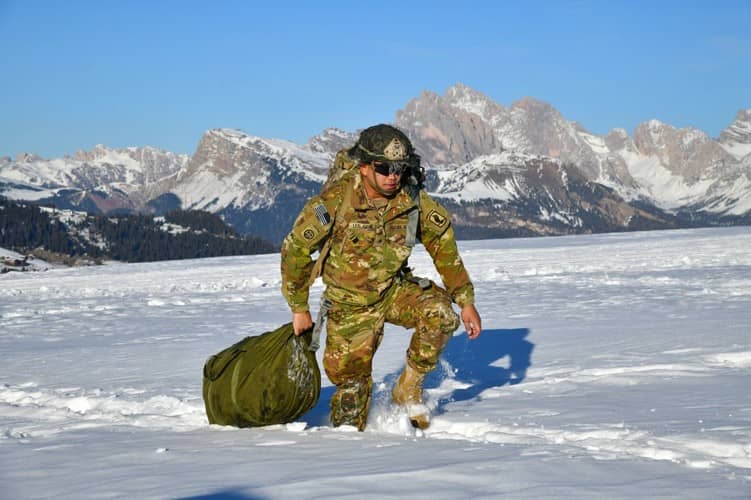 Soldier carrying gear snowy mountain terrain
