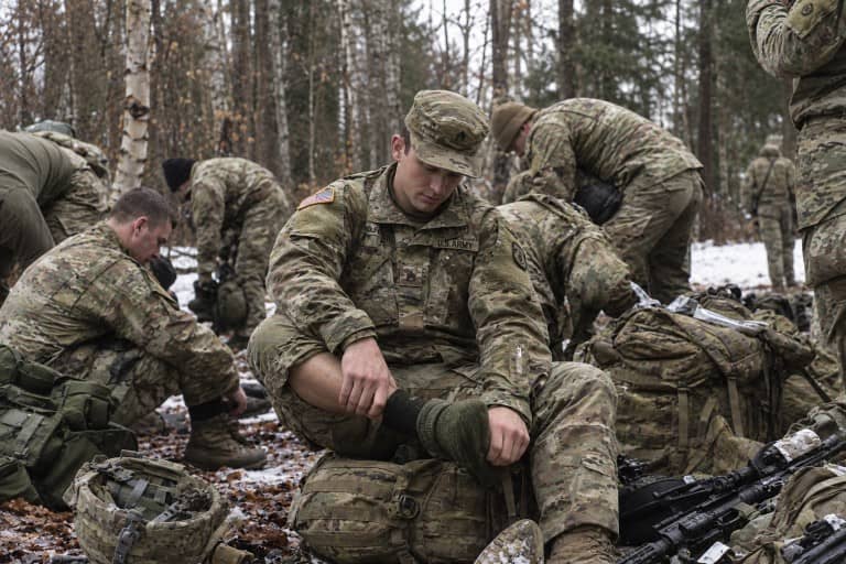 Soldier changing socks cold weather training snow