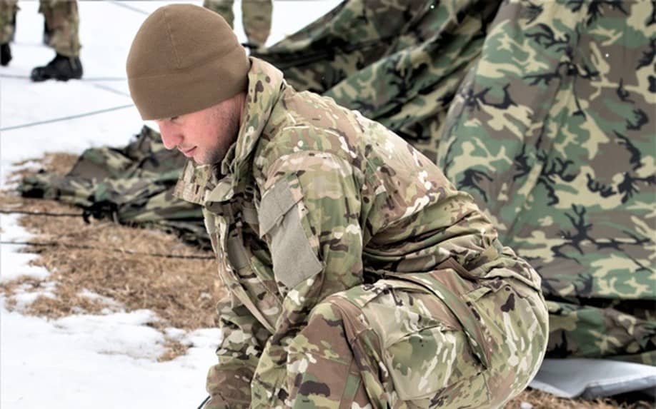 Soldier pitching tent in snow
