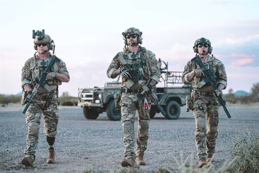 Armed soldiers in plate carriers before a jeep