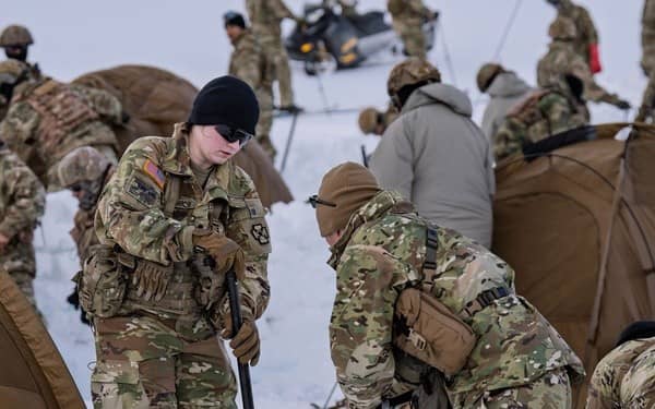 Soldiers digging in the snow wearing gloves