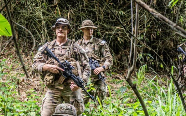 Soldiers walking in jungle with rifles