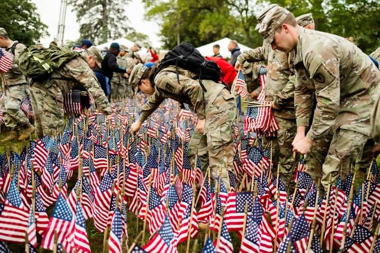 US Service members palcing flags on 9/11 memorial
